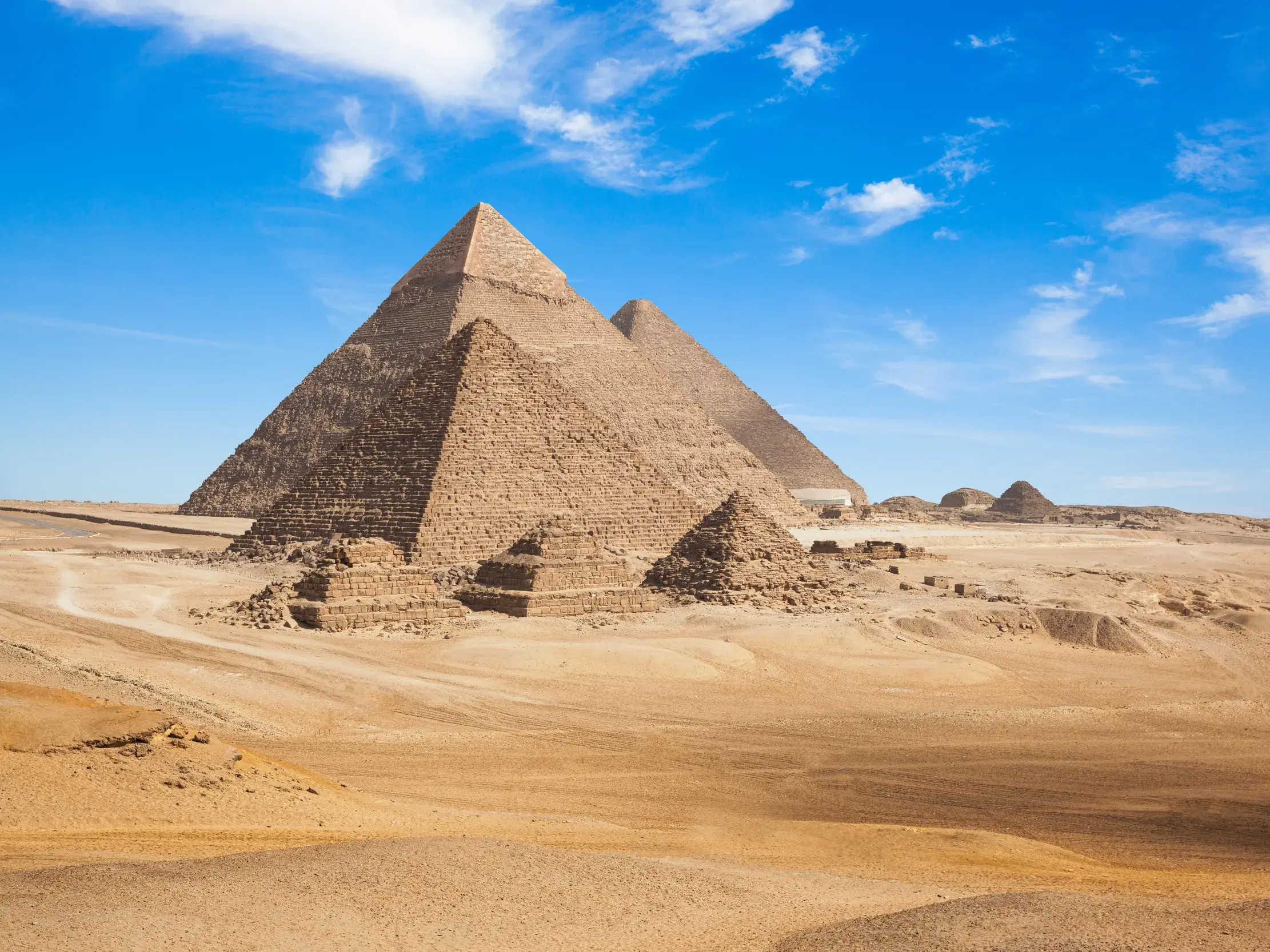 Die imposanten Pyramiden von Gizeh ragen bei strahlendem Sonnenschein aus der ägyptischen Wüste nahe Kairo empor.