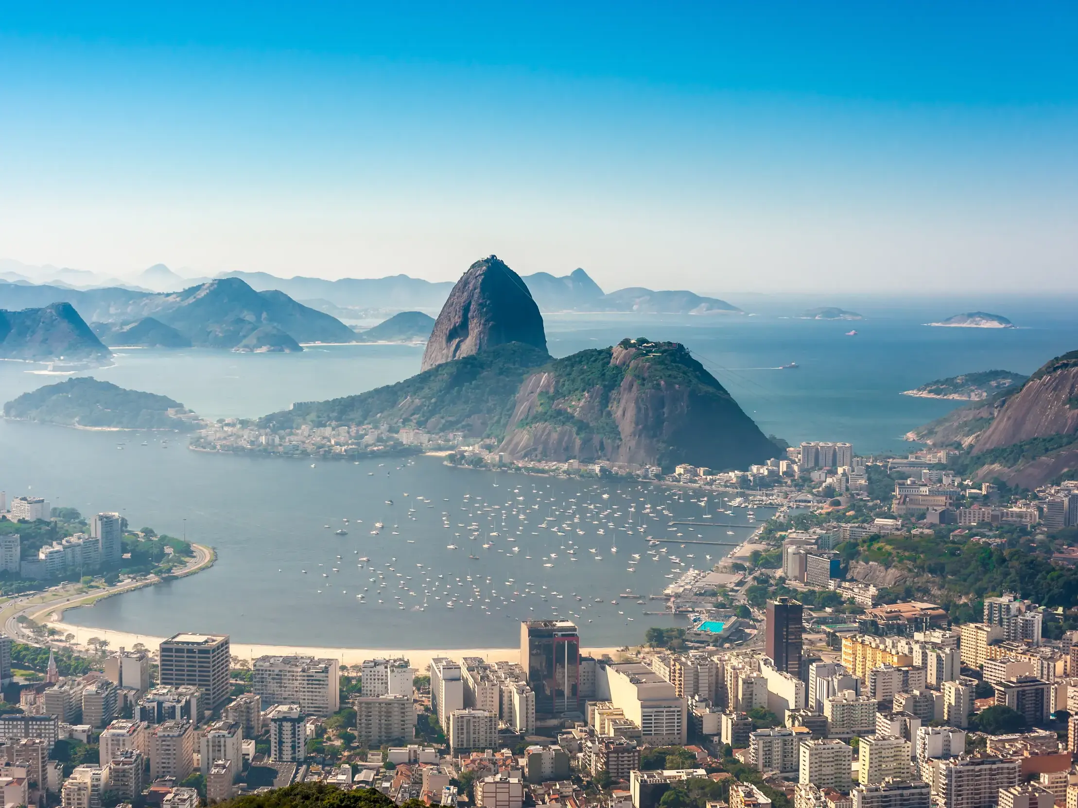 Weitblick auf den Zuckerhut und die Guanabara-Bucht in Rio de Janeiro bei strahlend blauem Himmel von einem Aussichtspunkt.