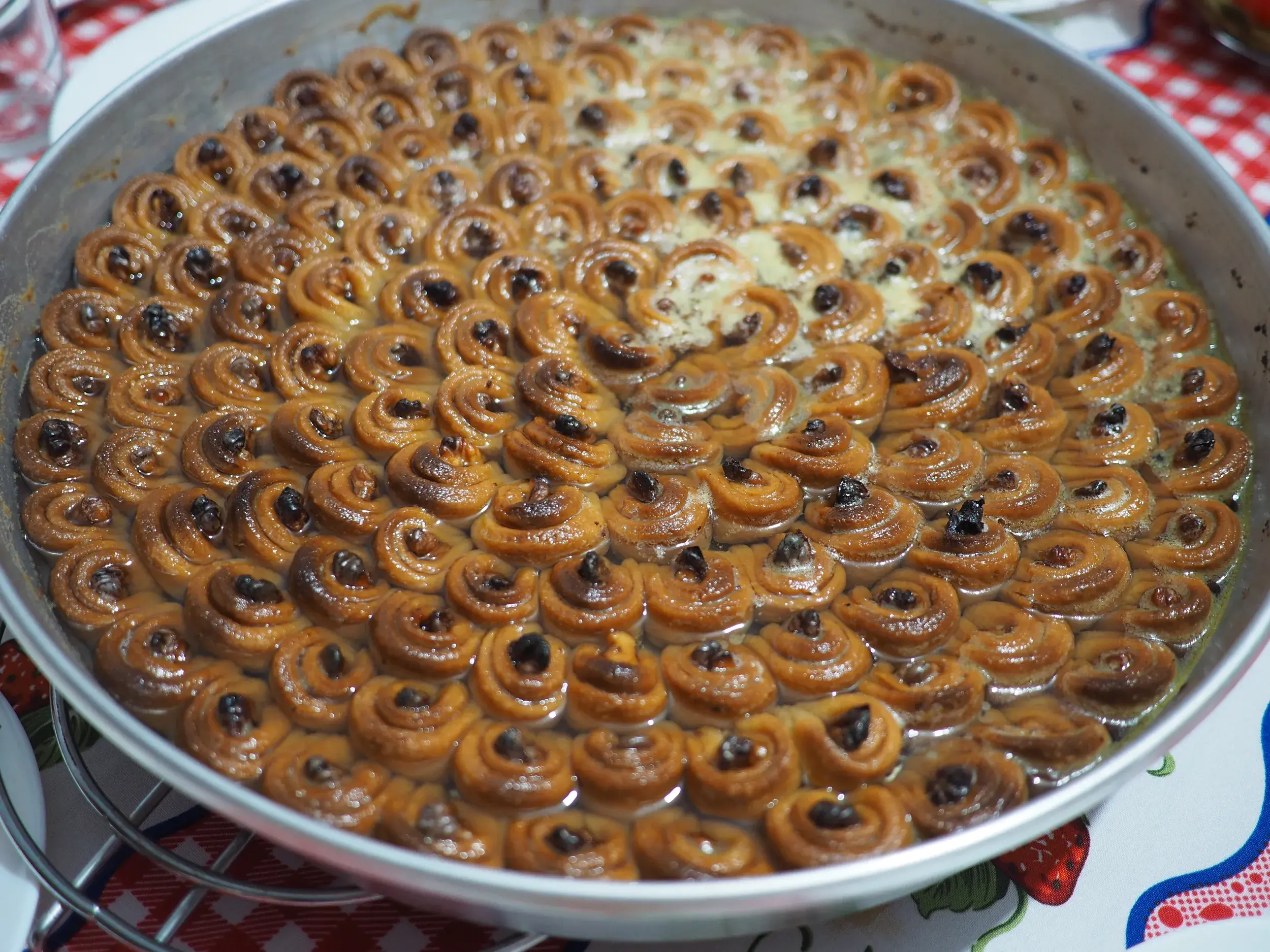 Nahaufnahme einer traditionellen, hausgemachten albanischen Süßspeise aus Gebäckröllchen, serviert in einer runden Backform.