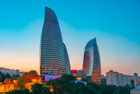 Die beleuchteten Flame Towers, das moderne Wahrzeichen von Baku, vor dem farbenprächtigen Himmel bei Sonnenuntergang.