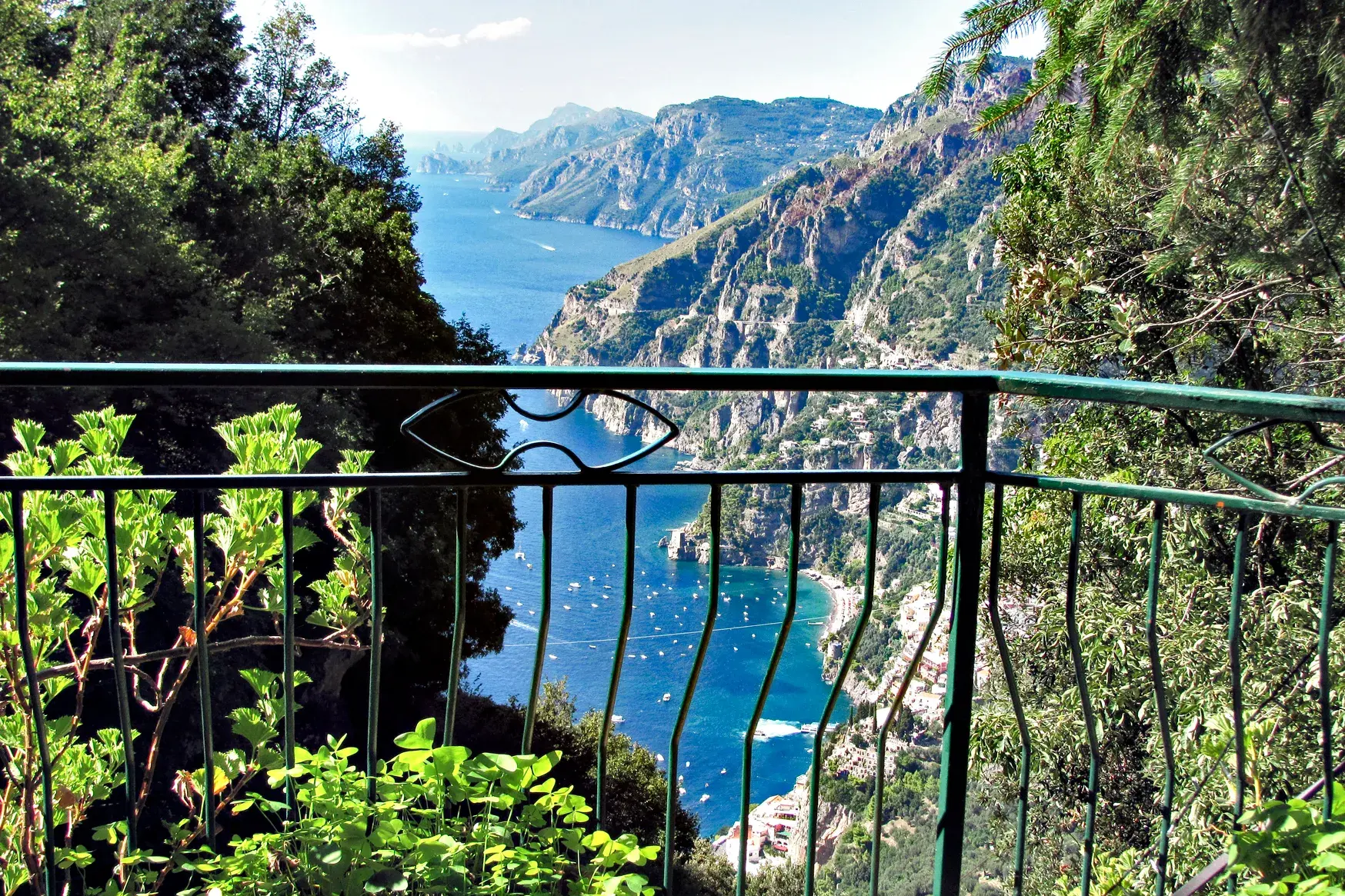 Panoramablick von einem Wanderweg auf die steile Amalfiküste mit dem Fjord von Furore und zahlreichen Booten im blauen Meer.