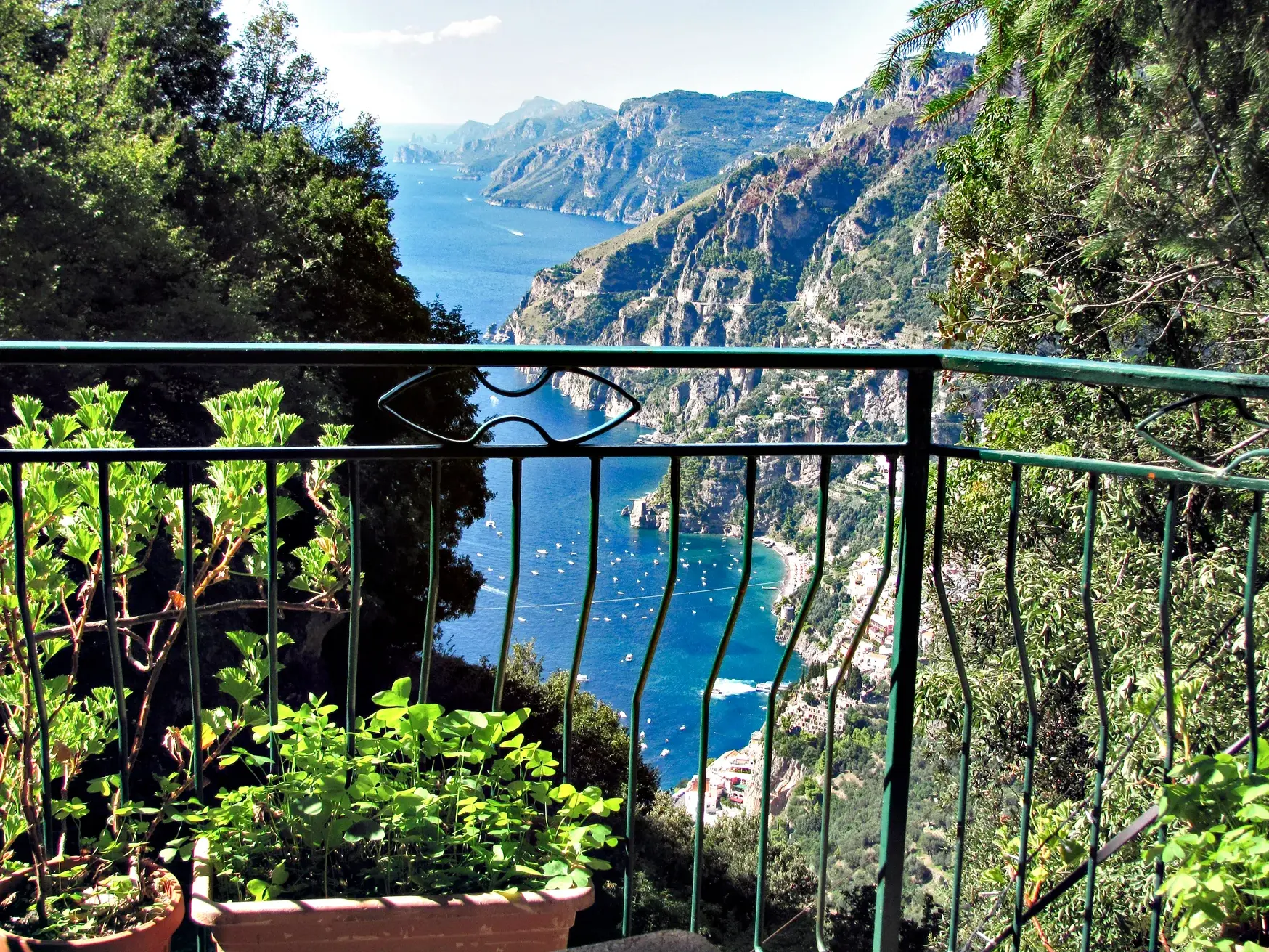 Panoramablick von einem Wanderweg auf die steile Amalfiküste mit dem Fjord von Furore und zahlreichen Booten im blauen Meer.