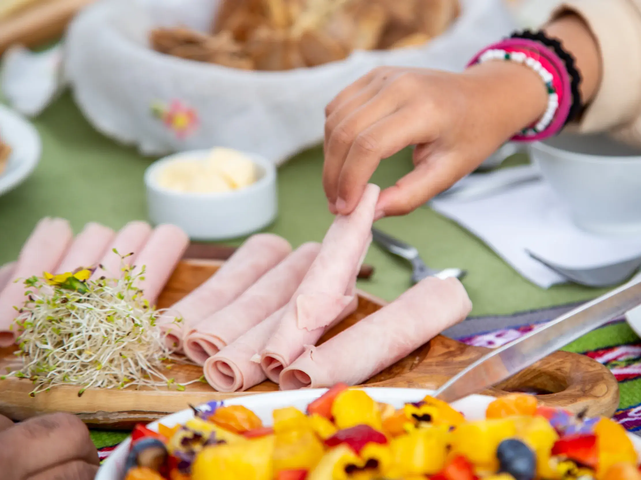 Reichhaltiges Frühstück mit Schinken, Obst und Brot als Stärkung für eine Wanderung in den Anden Perus.