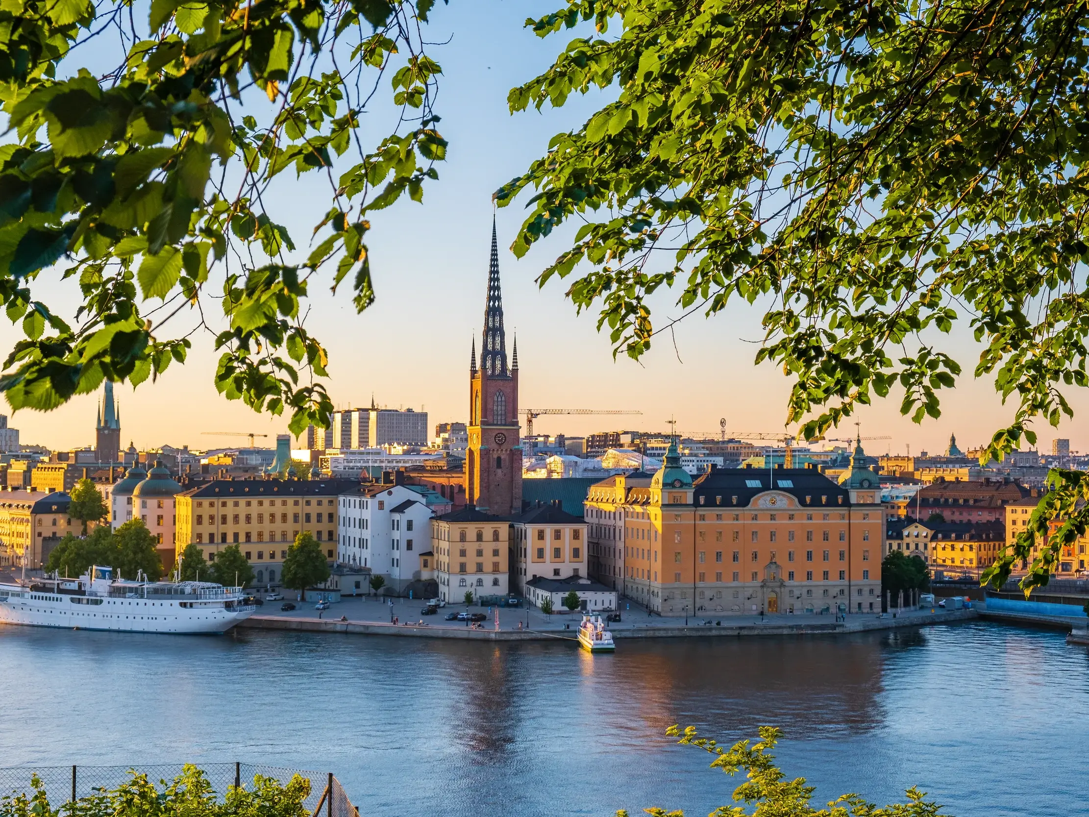 Malerischer Blick auf die Insel Riddarholmen in Stockholm mit der historischen Kirche im warmen Licht des Sonnenuntergangs.