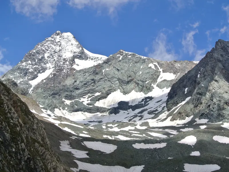 Imposanter, teils schneebedeckter Felsgipfel des Großglockners, umgeben von Geröllfeldern im Nationalpark Hohe Tauern.