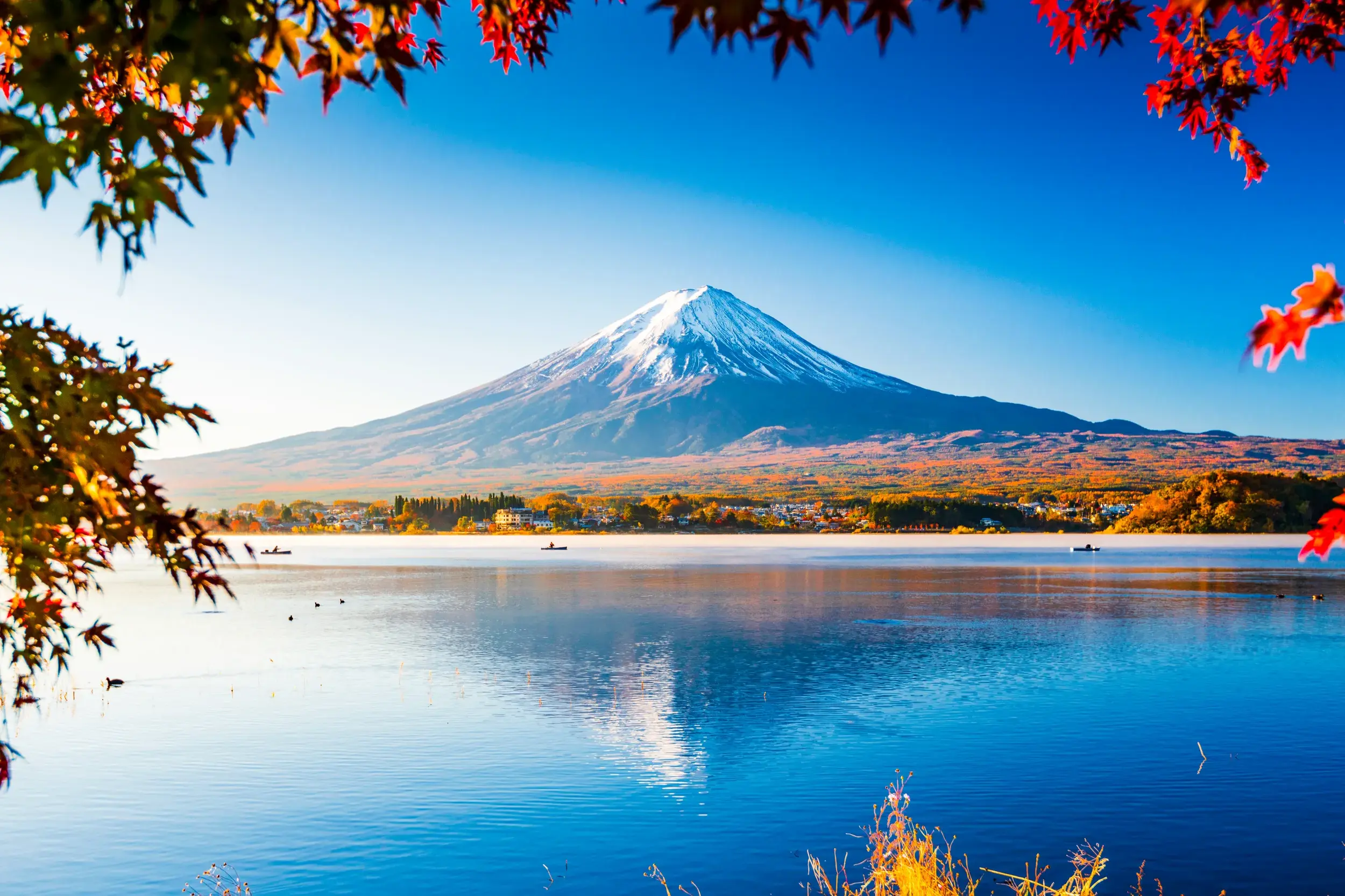 Herbstlicher Blick über den Ashi-See auf den majestätischen Fuji-san, eingerahmt von buntem Laub im Fuji-Hakone-Izu-Nationalpark.