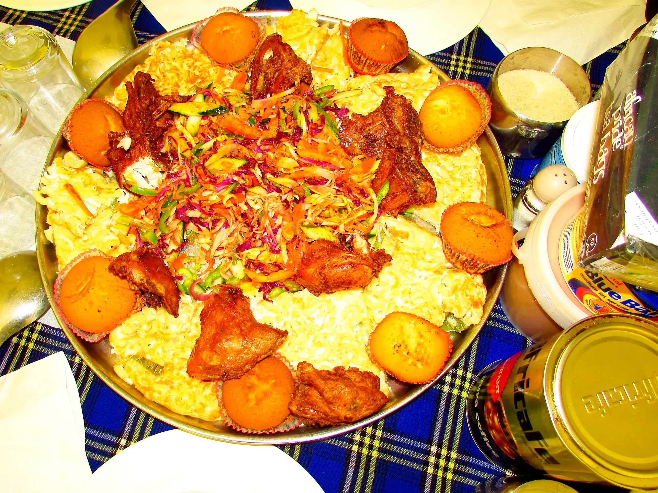Große Platte mit Hähnchen, Reis, Salat und Muffins als stärkende Mahlzeit beim Trekking am Kilimanjaro in Tansania.