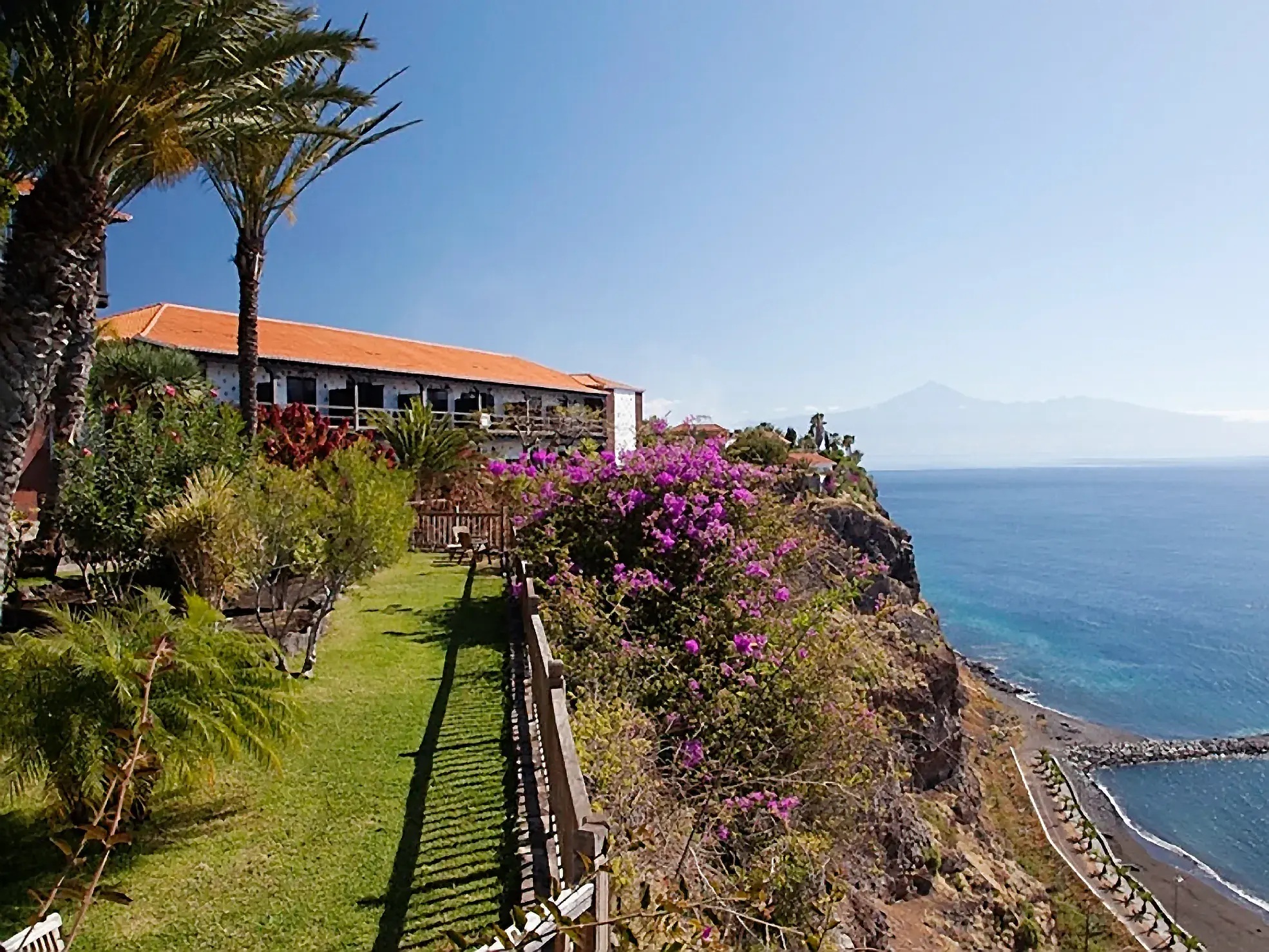 Gartenanlage des Parador de La Gomera auf einer Klippe mit Panoramablick über den Atlantik zum Teide auf Teneriffa.