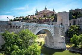 Historische Steinbrücke vor der Kulisse der Stadt Toledo und der Festung Alcázar