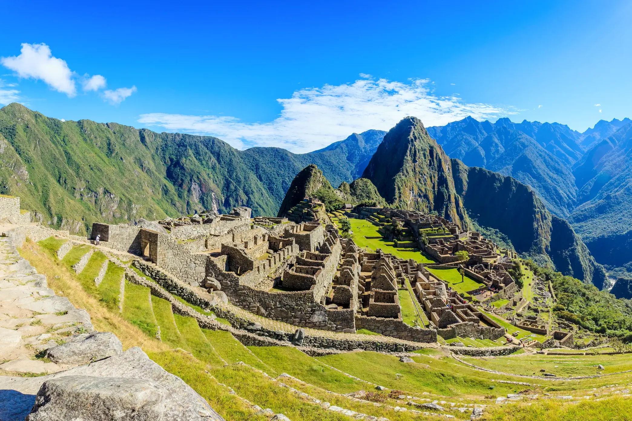 Die Ruinen der Inkastadt Machu Picchu mit Terrassenfeldern und dem Berg Huayna Picchu auf einer Studienreise in Peru.