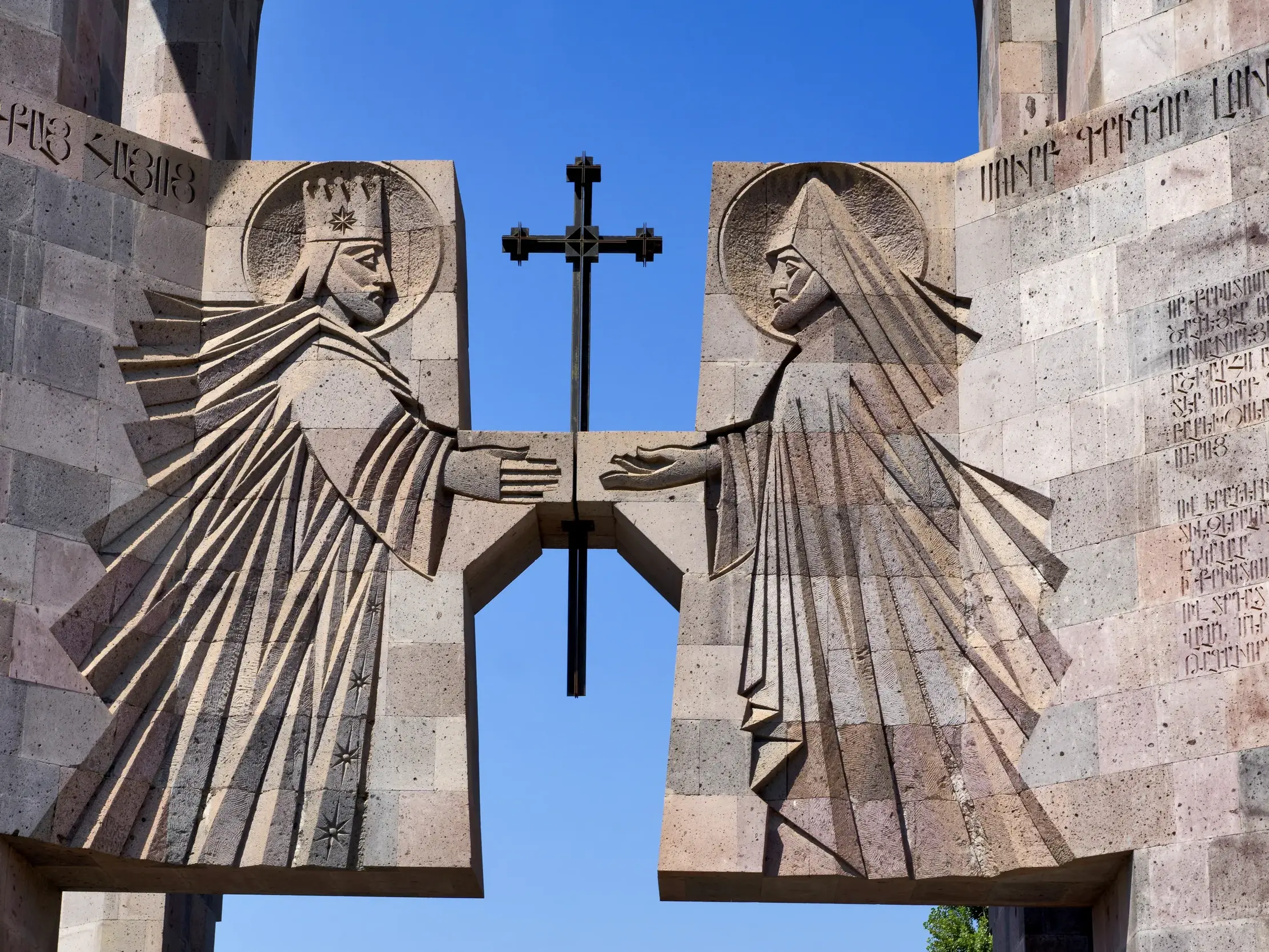 Das Vardan-Mamikonian-Denkmal in Jerewan: Zwei Steinreliefs historischer Figuren umrahmen ein armenisches Kreuz.