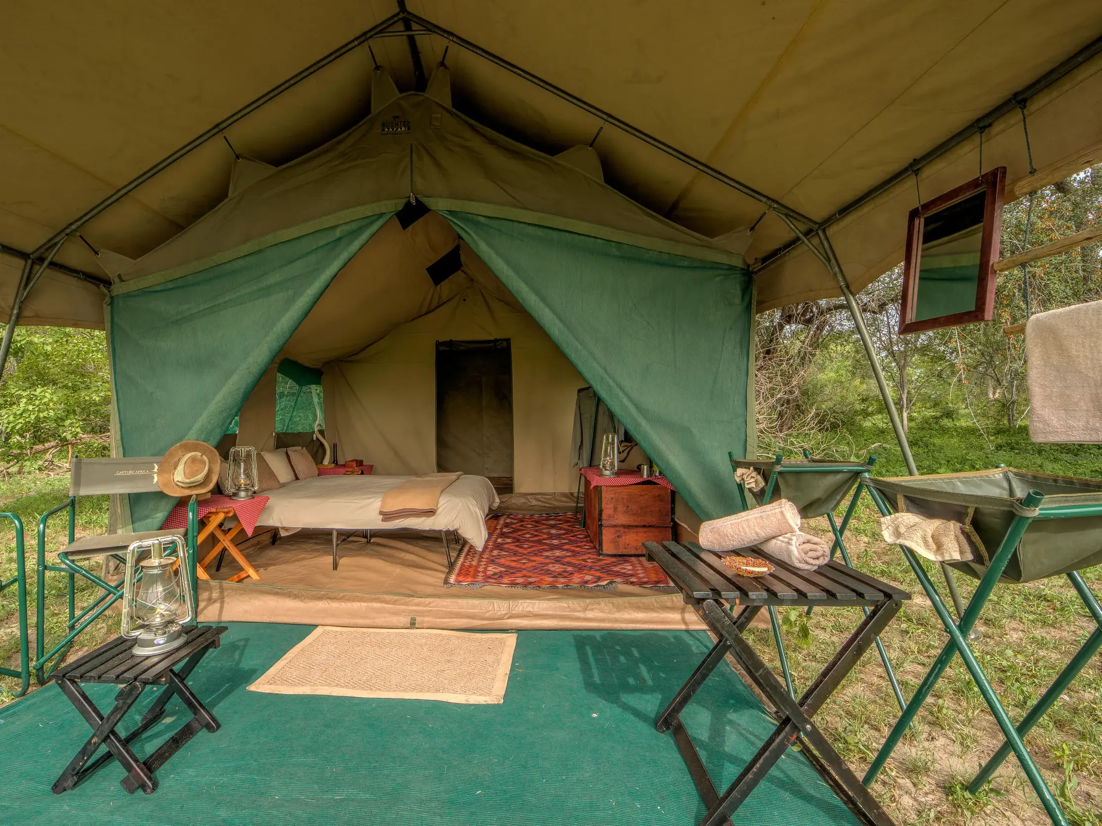 Einblick in ein komfortables Safarizelt mit Veranda und Stühlen im Zeltcamp am Moremi-Wildreservat in Botswana.
