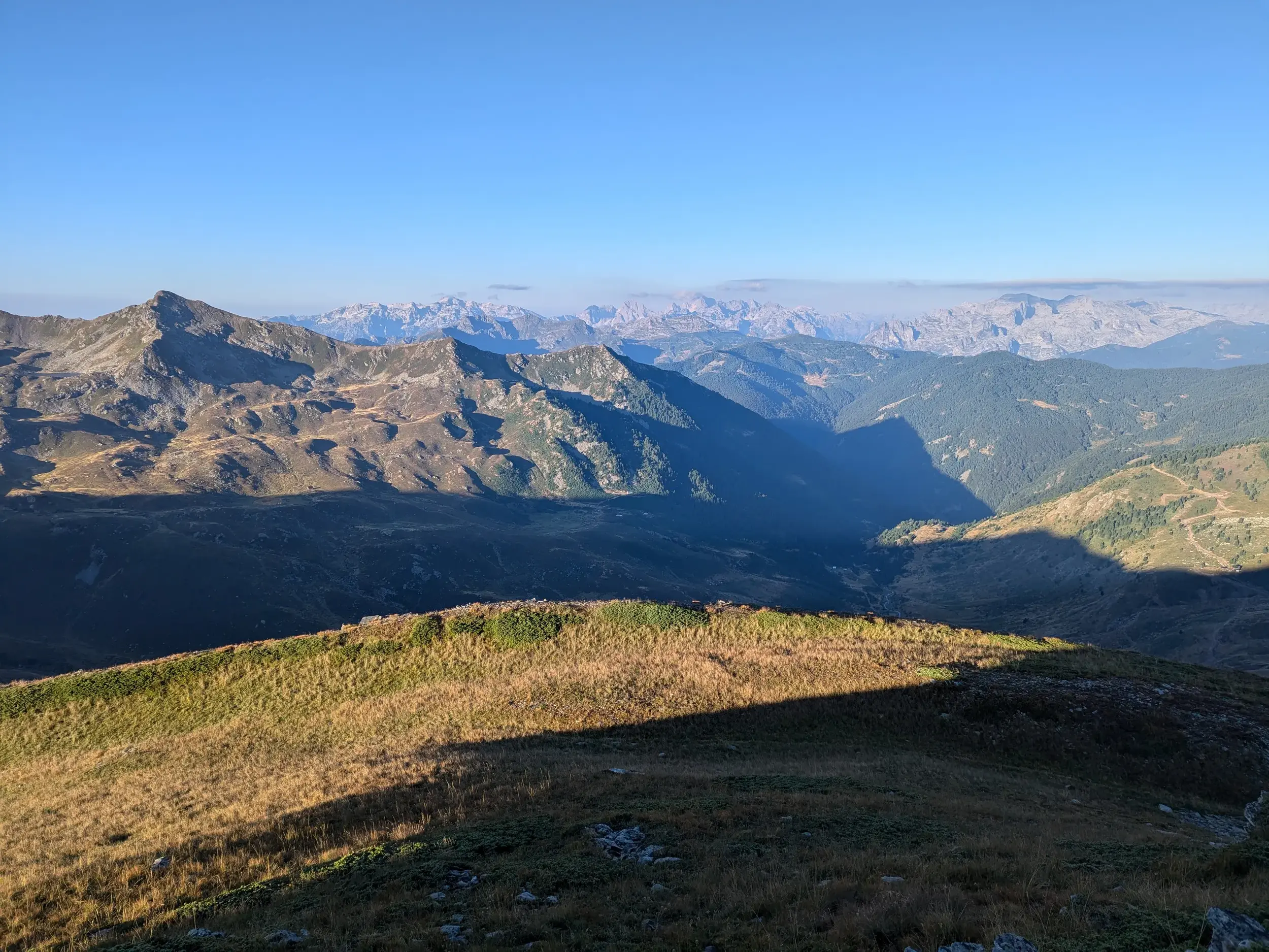Panoramablick beim Trekking auf dem Peaks of the Balkans Trail über die weite Berglandschaft der Albanischen Alpen im Morgenlicht.