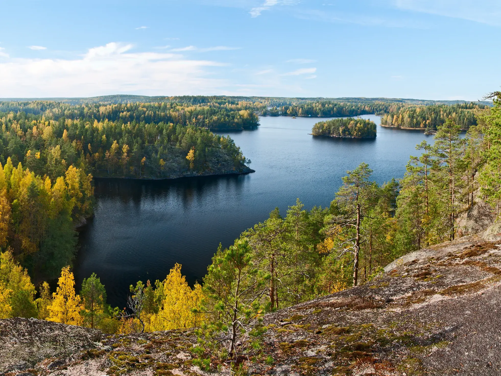 Panoramablick vom Aussichtspunkt Katajavuori auf einen See und die bunten Herbstwälder des Repovesi-Nationalparks.