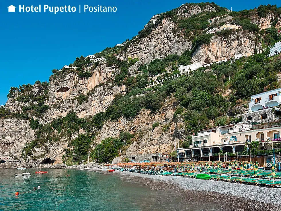Das Hotel Pupetto liegt direkt am Kieselstrand von Positano, eingebettet in die steile Felsküste der Amalfiküste.