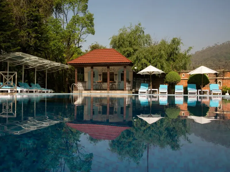 Ein ruhiger Hotelpool mit Pavillon in Nepal, der nach einer Wanderung zur entspannten Erholung einlädt.