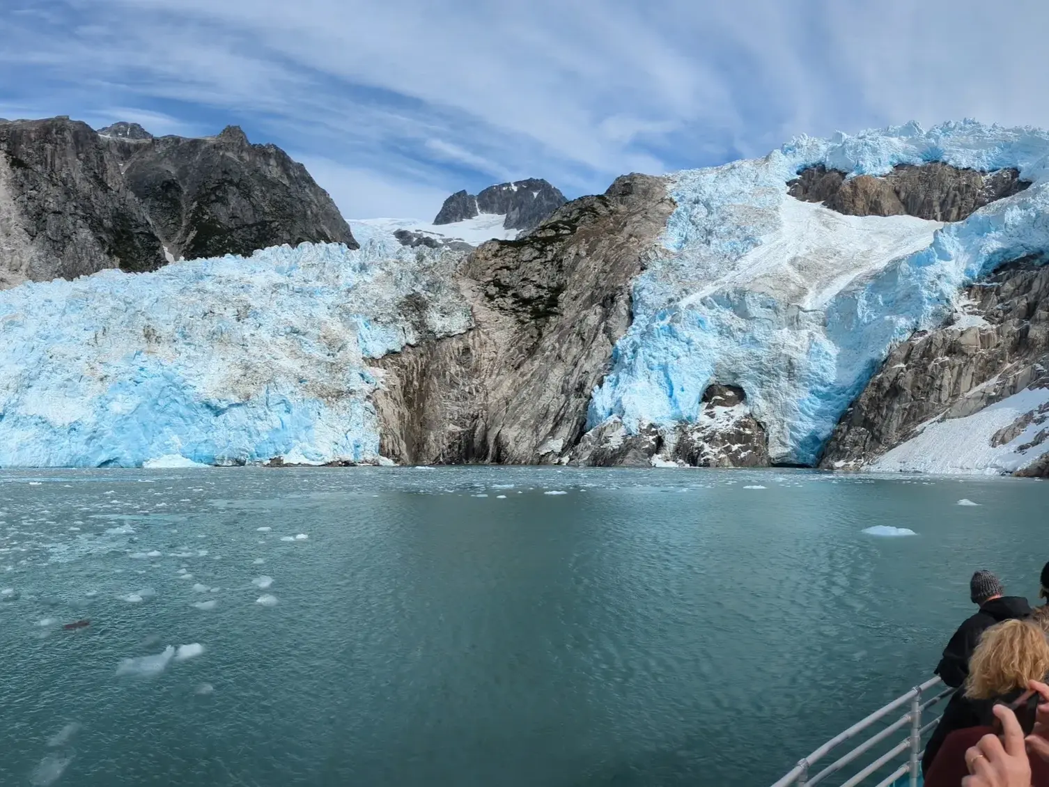 Gruppenreise in Alaska: Teilnehmer einer Bootstour bestaunen die beeindruckende Gletscherfront im Kenai Fjords Nationalpark.