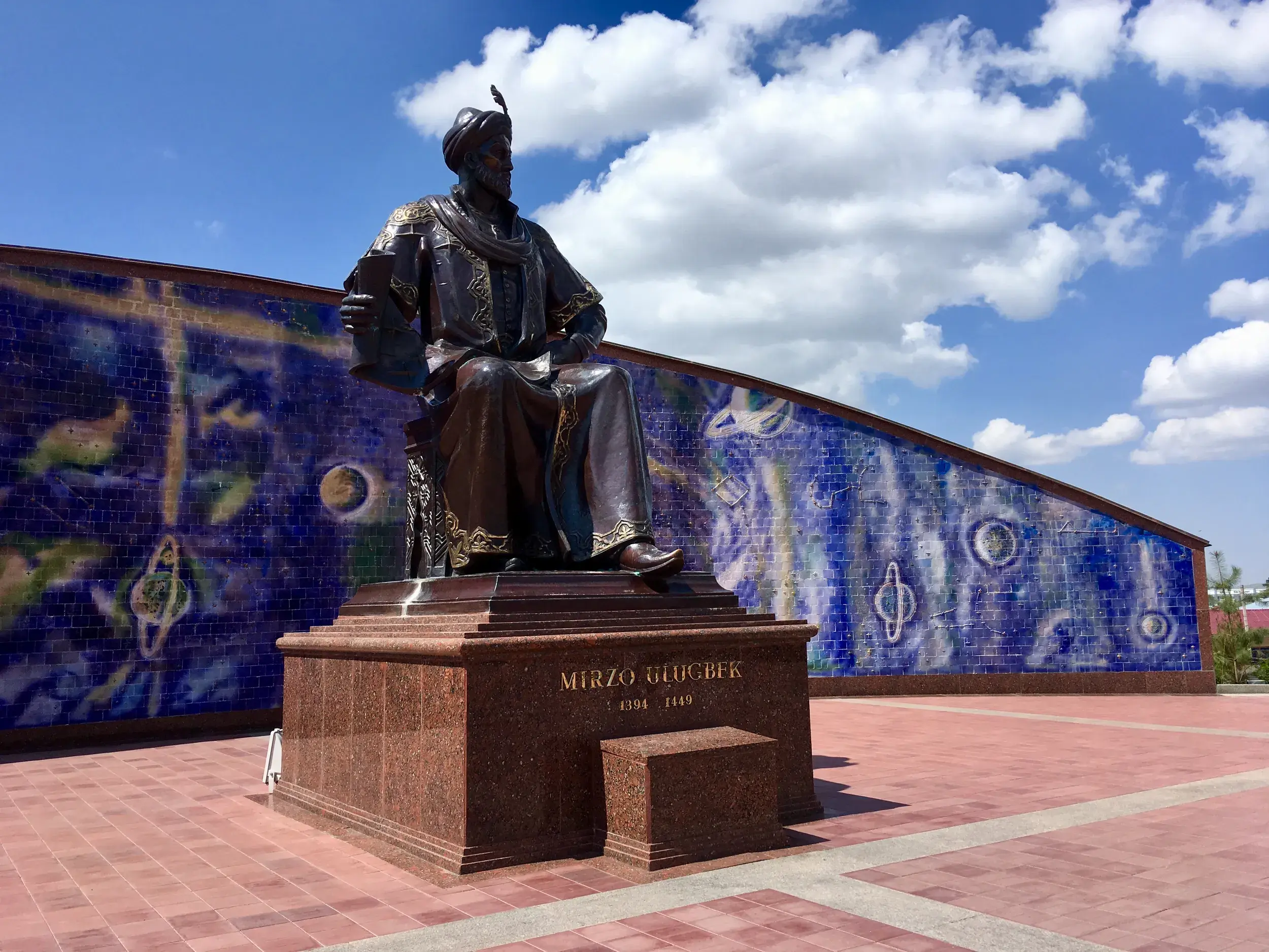 Majestätische Bronzestatue des Astronomen Ulugh Beg vor einer blauen Mosaikwand am Observatorium in Samarkand, Usbekistan.