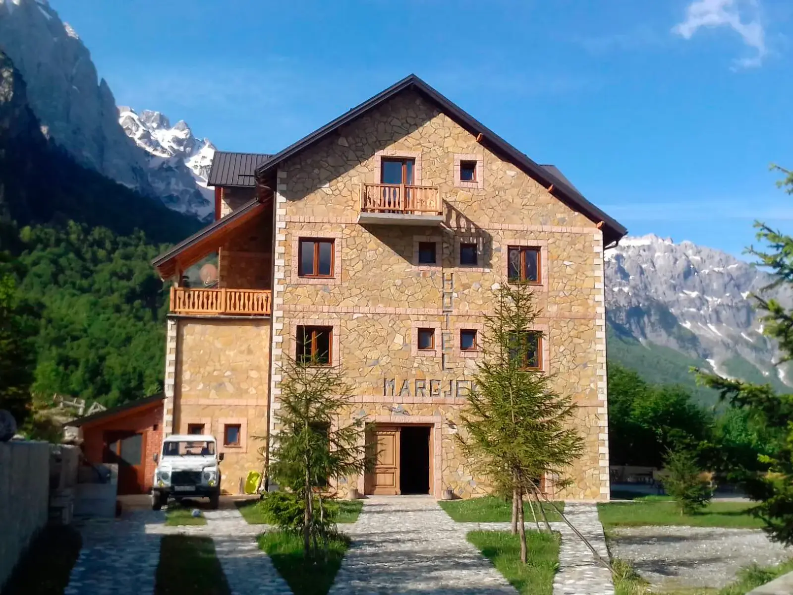 Familiäres Berghotel mit Steinfassade im Valbona-Nationalpark, umgeben von den beeindruckenden albanischen Bergen.