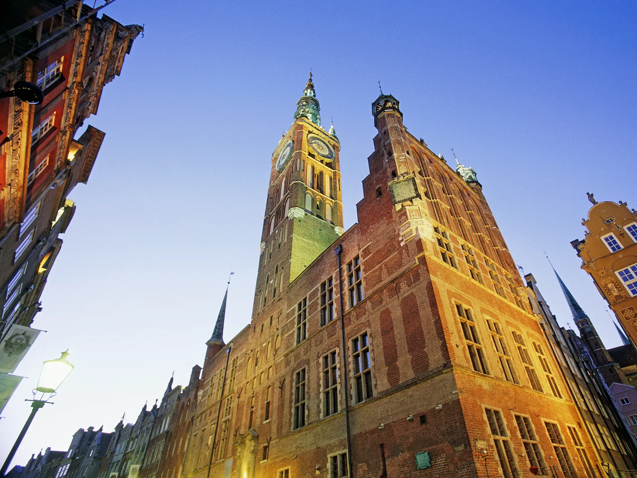 Das historische Rathaus der Danziger Rechtstadt und bunte Patrizierhäuser am Langen Markt in Danzig im Abendlicht.