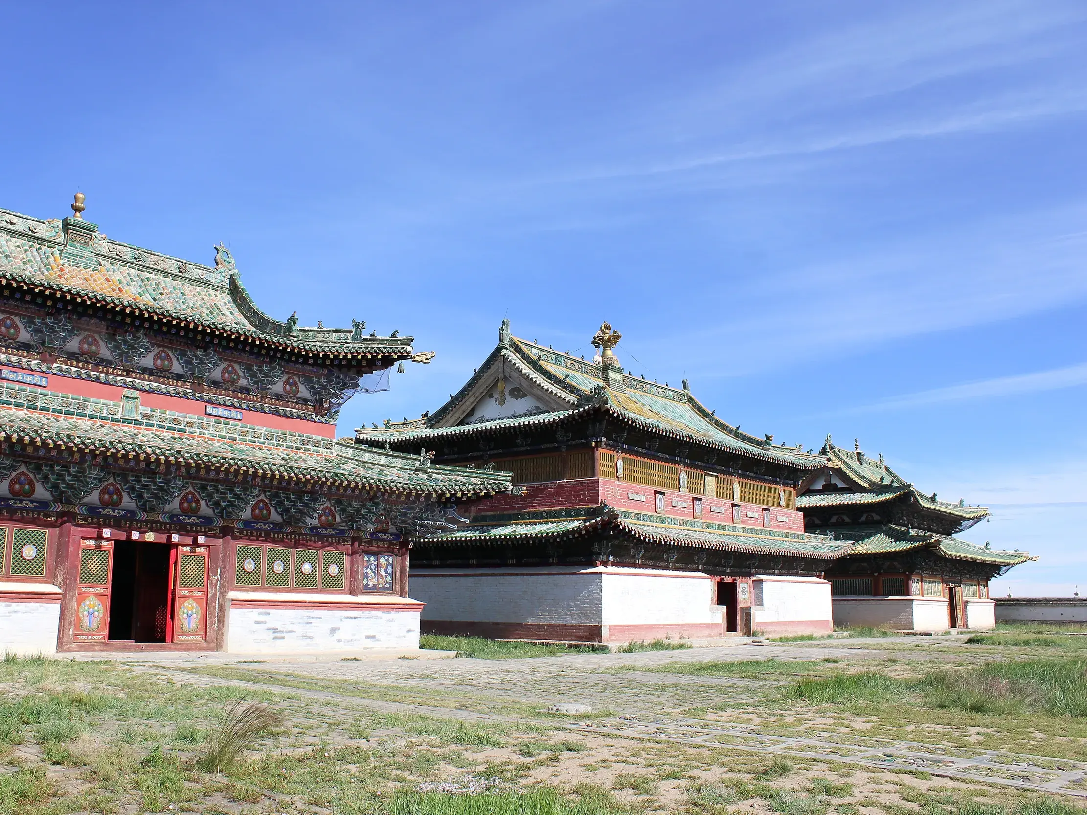 Tempelgebäude des buddhistischen Klosters Erdene Zuu in Karakorum mit verzierten, grünen Dächern in der mongolischen Steppe.