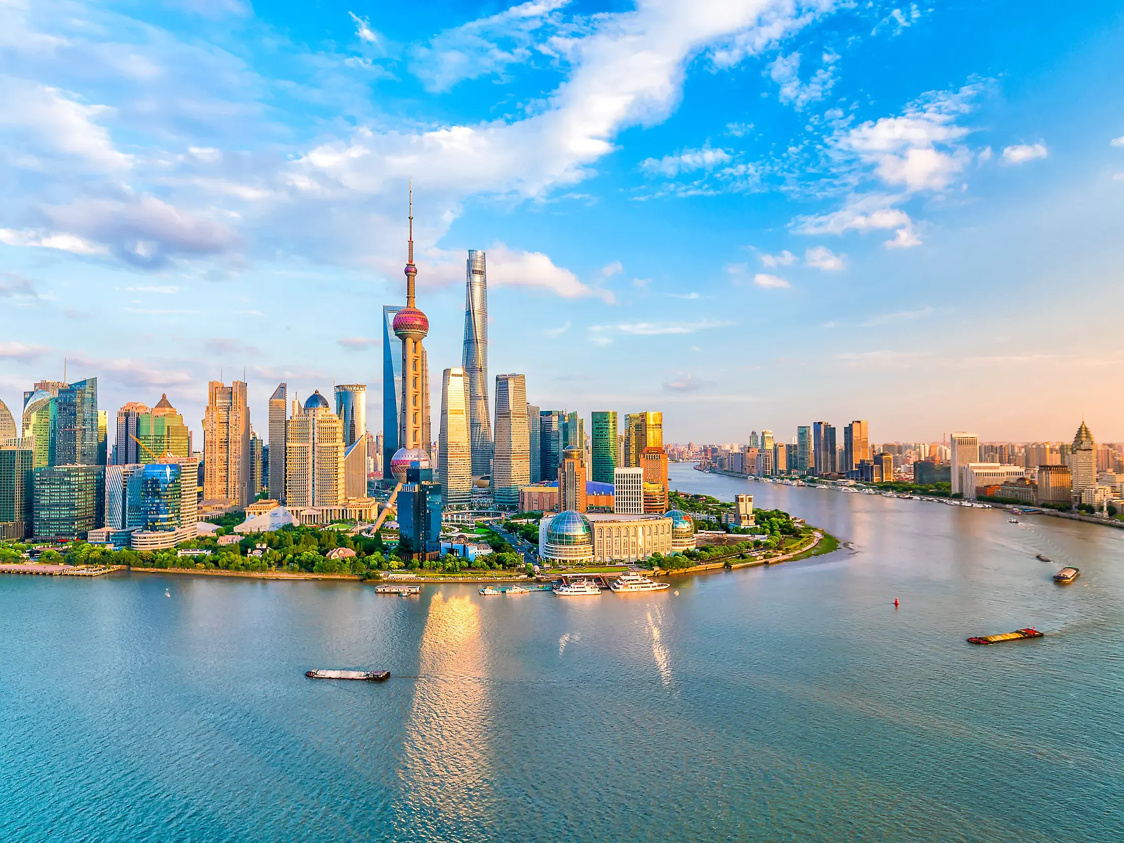 Die beeindruckende Skyline von Shanghai mit dem Shanghai Tower und dem Oriental Pearl Tower spiegelt sich im Huangpu-Fluss.