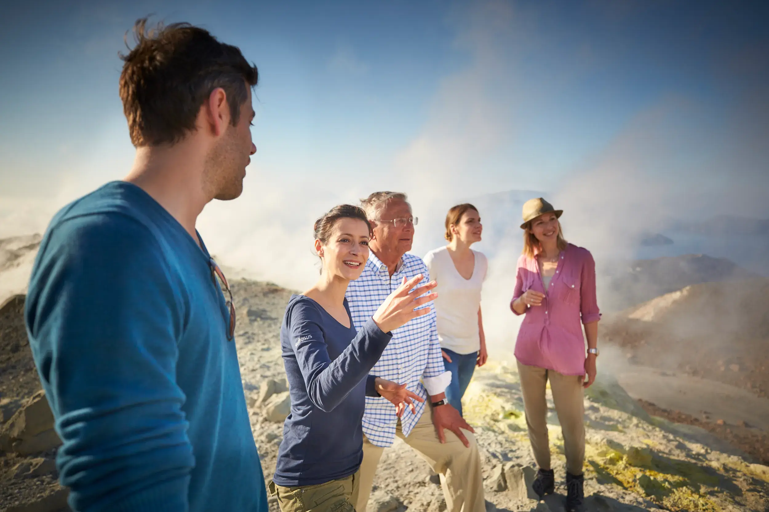 Eine Studiosus-Reiseleiterin erklärt einer kleinen Gruppe die dampfende Kraterlandschaft des Ätna.