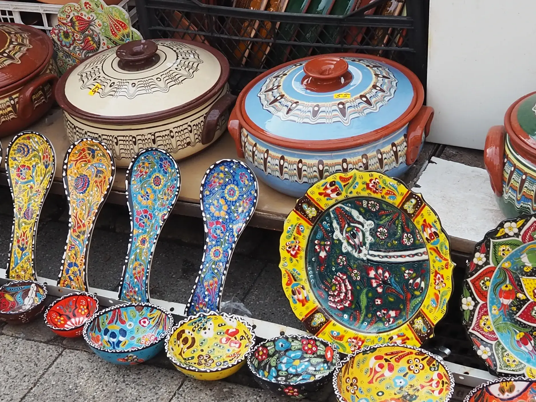 Bunte, handbemalte bulgarische Keramik mit Töpfen, Schalen und Löffeln ausgestellt auf einem Marktstand in Sofia.