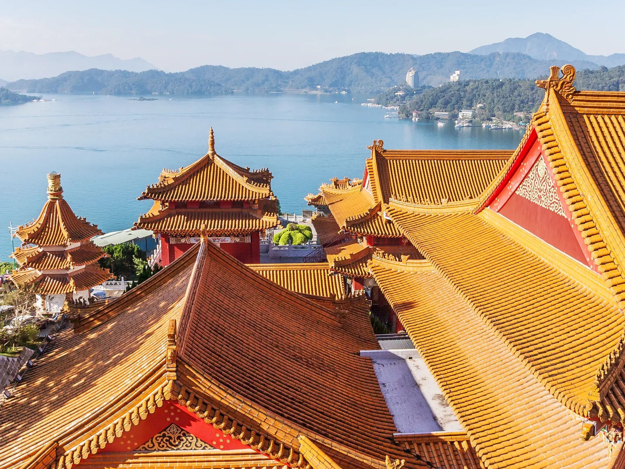 Die geschwungenen, orangen Dächer des Wenwu-Tempels überblicken den blauen Sonne-Mond-See und die grüne Berglandschaft Taiwans.