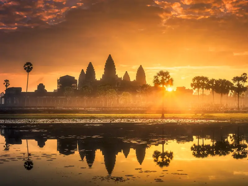 Spektakulärer Sonnenaufgang über der Tempelanlage Angkor Wat in Kambodscha, die sich in einem Teich spiegelt.