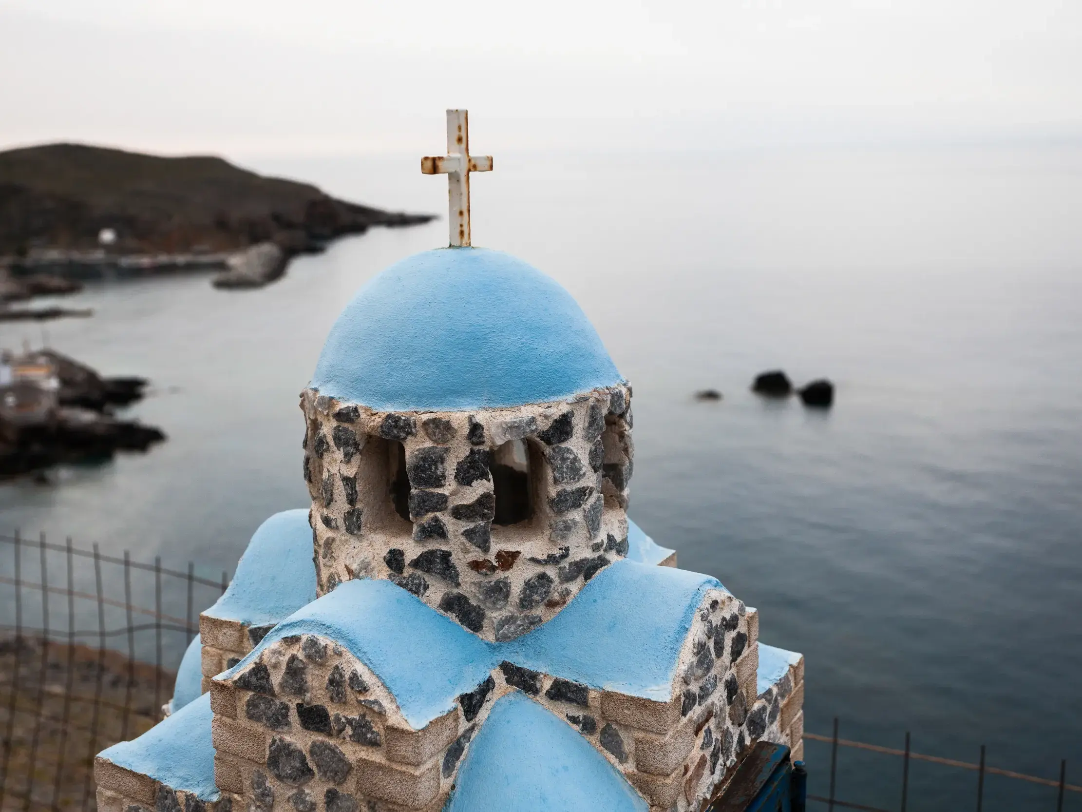 Steinmodell einer Kapelle mit blauer Kuppel überblickt die ruhige Küste von Loutro während einer Wanderreise auf Kreta.