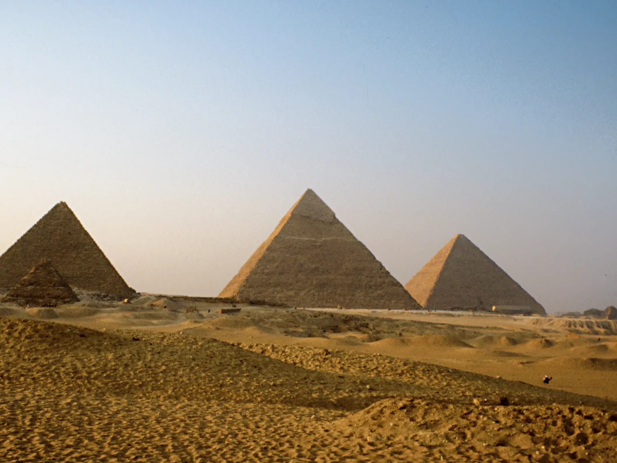 Die weltberühmten Pyramiden von Gizeh ragen aus der weiten Sandlandschaft der ägyptischen Wüste bei Kairo empor.
