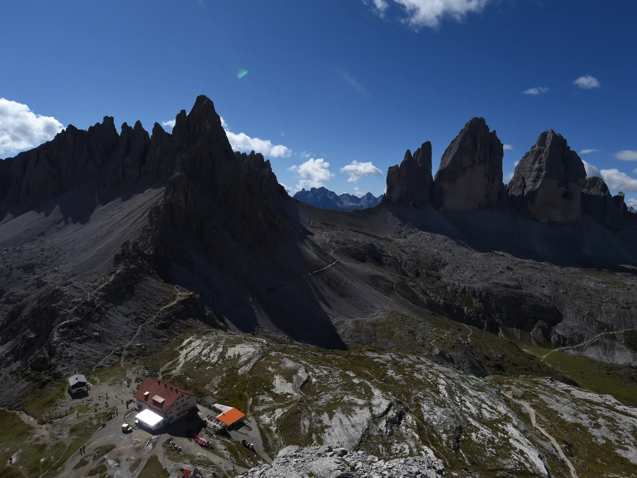 Panoramablick auf die majestätischen Drei Zinnen im UNESCO Welterbe Dolomiten mit der Dreizinnenhütte im Vordergrund.