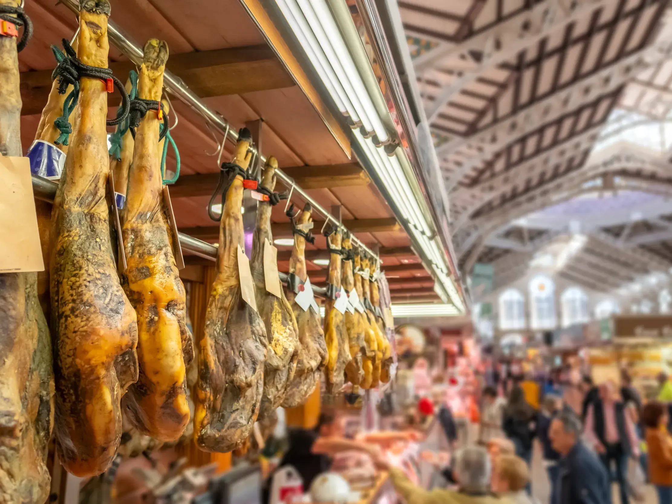 Traditioneller Jamón, Schinken, an einem Stand in der historischen Jugendstil-Markthalle des Mercat Central in Valencia.