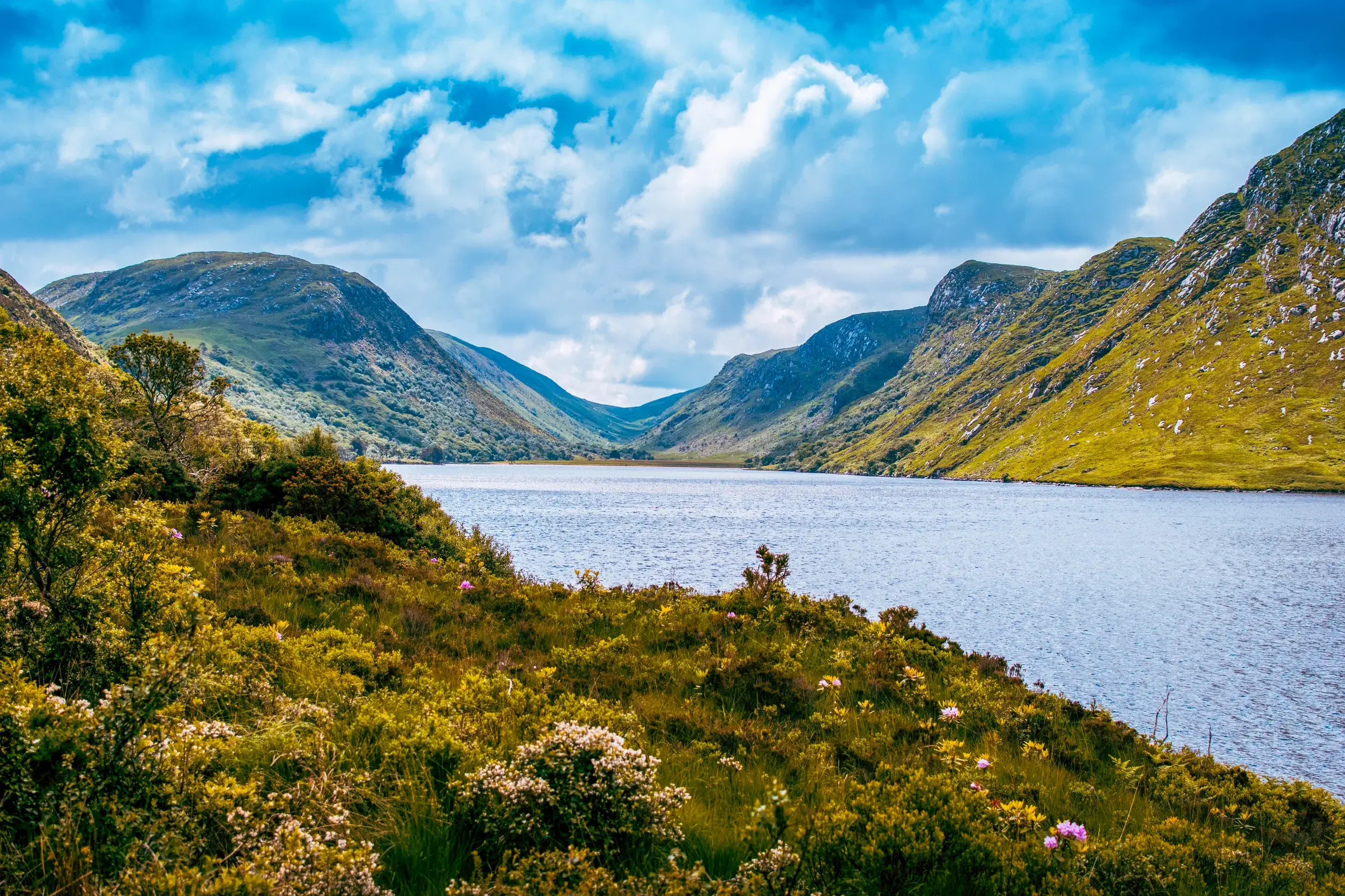 Malerischer Blick auf den von steilen, grünen Bergen umgebenen See Lough Beagh bei einer Wanderung im Glenveagh Nationalpark.