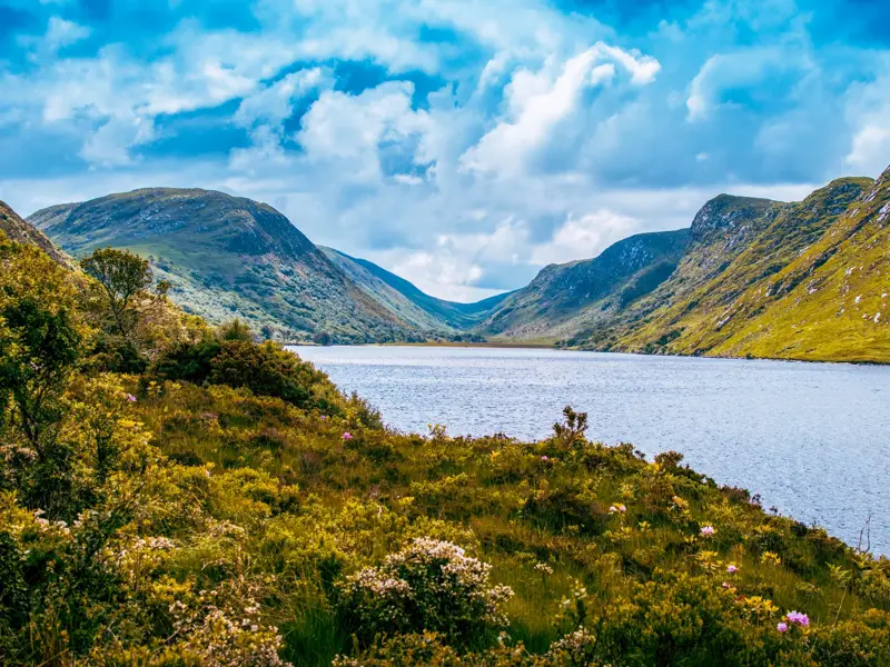 Malerischer Blick auf den von steilen, grünen Bergen umgebenen See Lough Beagh bei einer Wanderung im Glenveagh Nationalpark.