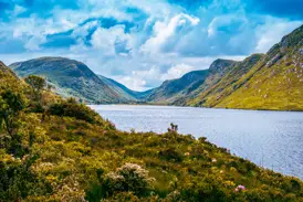 Malerischer Blick auf den von steilen, grünen Bergen umgebenen See Lough Beagh bei einer Wanderung im Glenveagh Nationalpark.