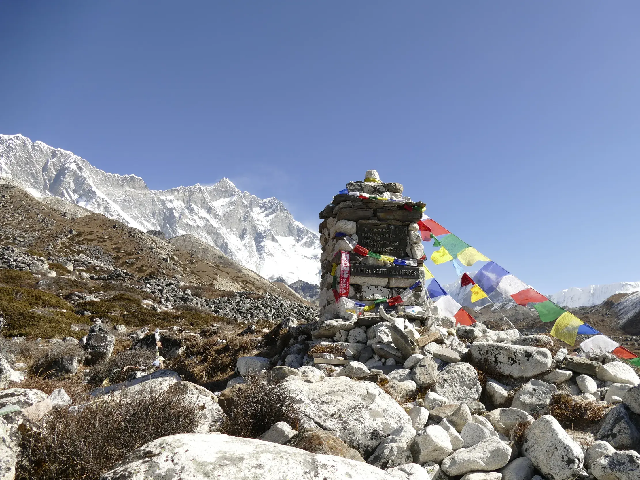 Gedenkschrein für Bergsteiger, geschmückt mit Gebetsfahnen, in der Felslandschaft nahe Lobuche im Khumbu-Himalaya.