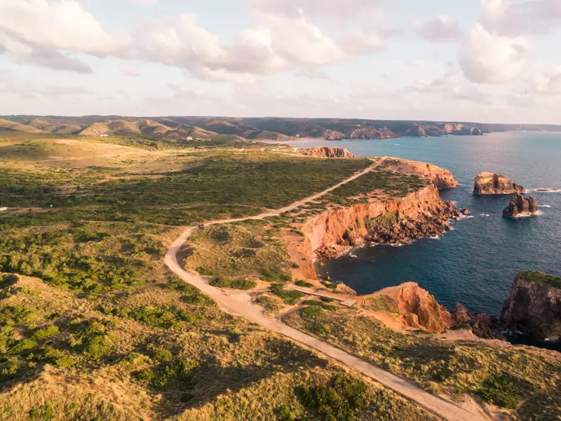 Der Fischerpfad der Rota Vicentina schlängelt sich entlang der roten Felsklippen an Portugals wilder Costa Vicentina.