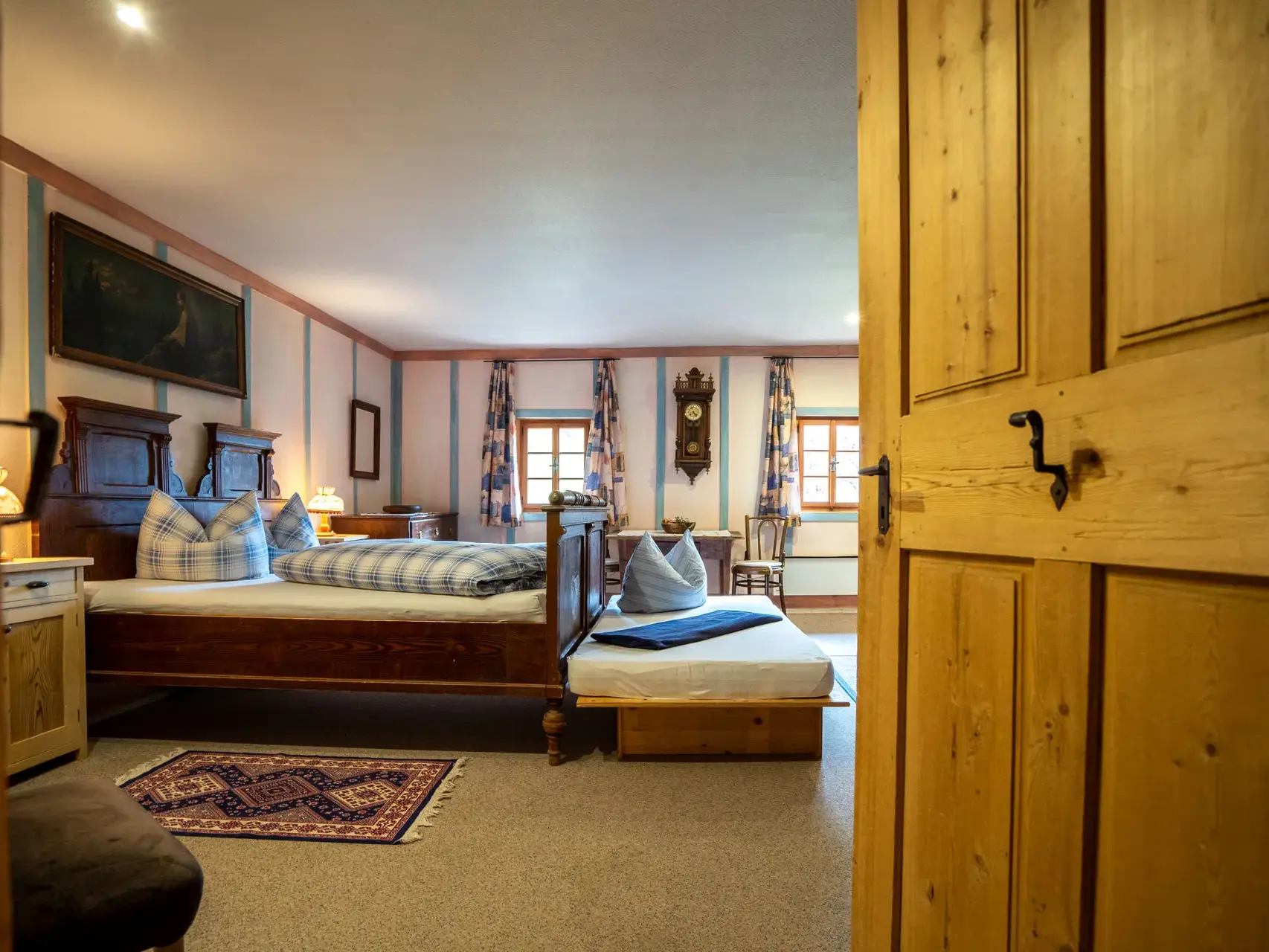 Rustikales Schlafzimmer im denkmalgeschützten Wurzerhof im Villgratental mit Holzbett und traditioneller Einrichtung.