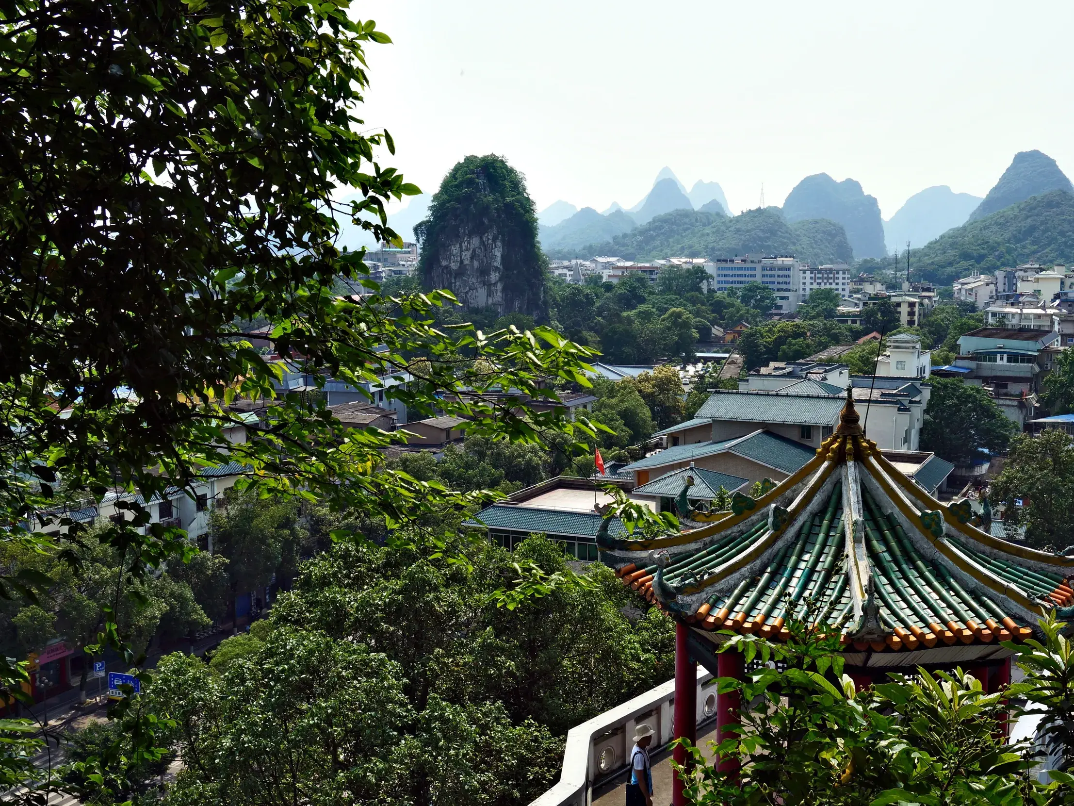 Pagodendach im Vordergrund mit Blick auf die Stadt Guilin und die markante Karstlandschaft in der Provinz Guangxi.