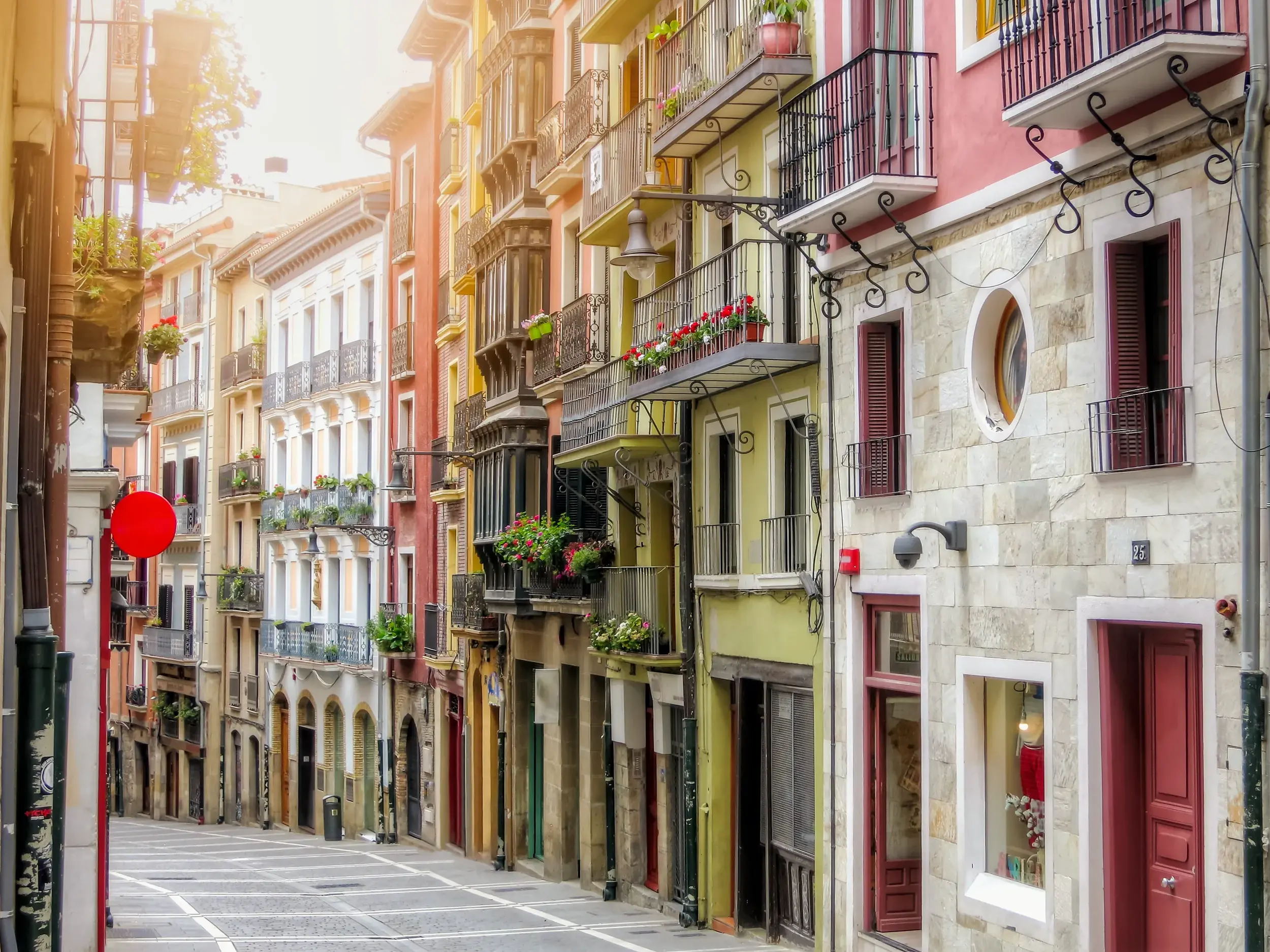 Gasse in der Altstadt von Pamplona mit bunten Häuserfassaden und Balkonen, eine Station der Studiosus-Studienreise.
