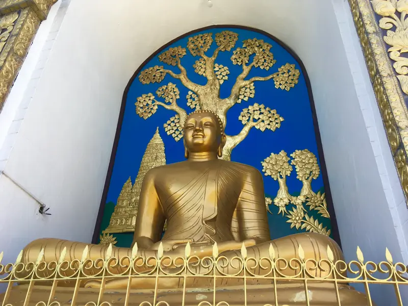 Goldene Buddha-Statue im Lotussitz in einer Nische des Shanti-Stupa bei Pokhara, Nepal, während einer Wanderreise.