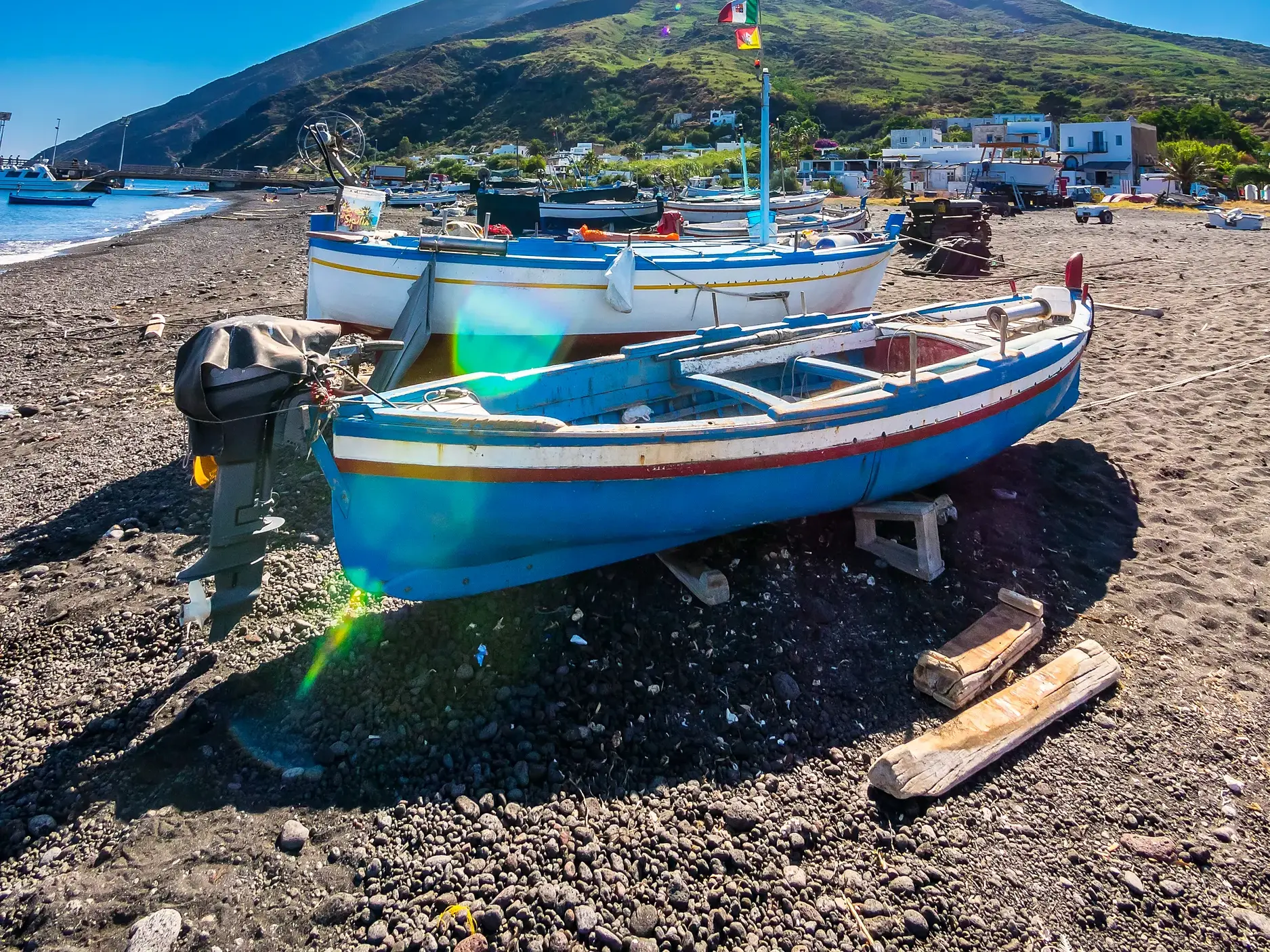 Zwei bunte Fischerboote am charakteristischen schwarzen Lavastrand von Stromboli auf den Äolischen Inseln.