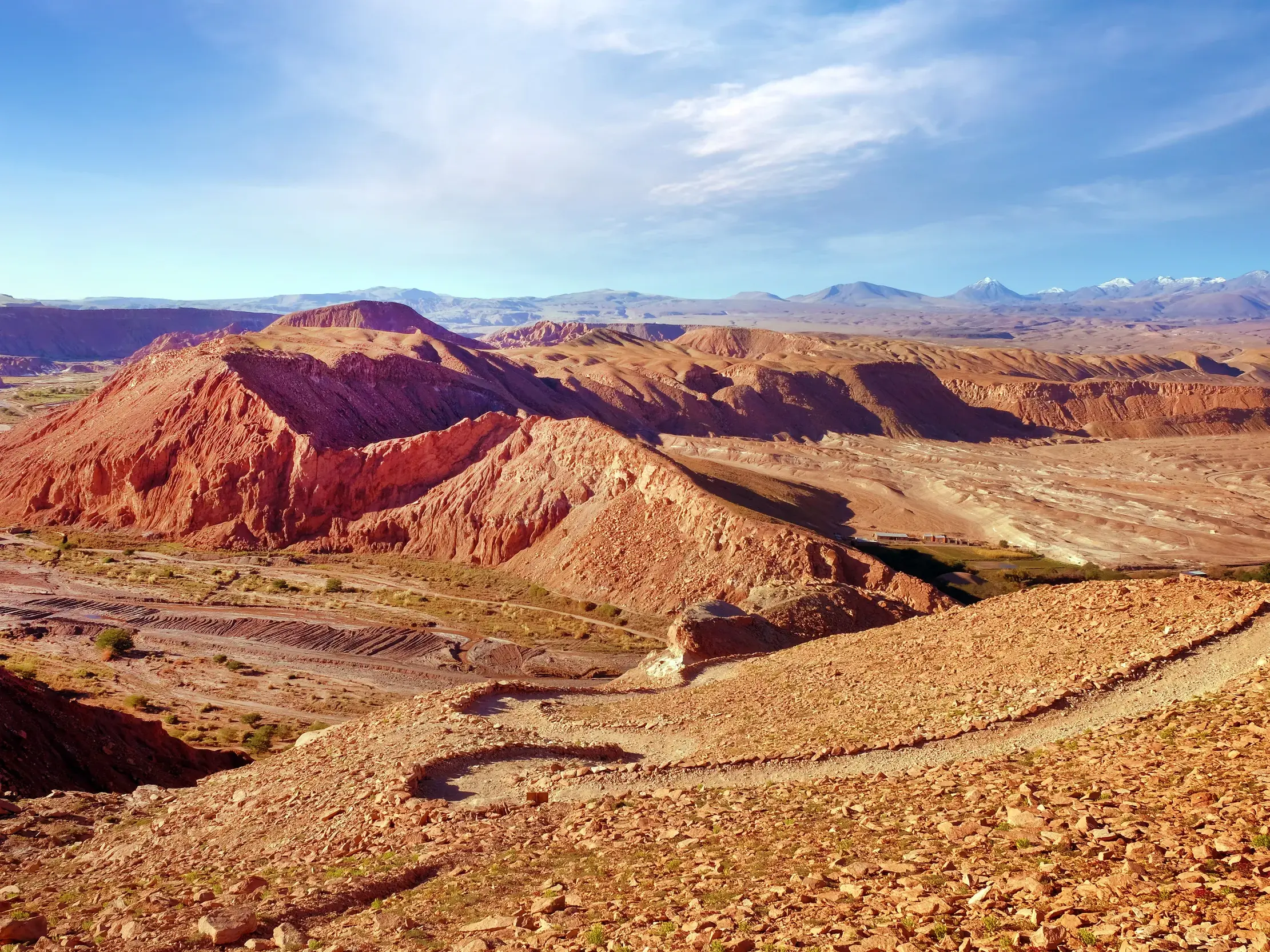 Blick vom Wanderweg bei der Festung Pukara de Quitor auf die rote, trockene Landschaft der Atacama-Wüste in Chile.