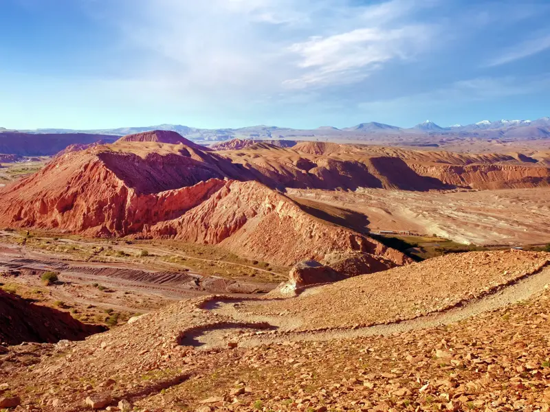 Blick vom Wanderweg bei der Festung Pukara de Quitor auf die rote, trockene Landschaft der Atacama-Wüste in Chile.