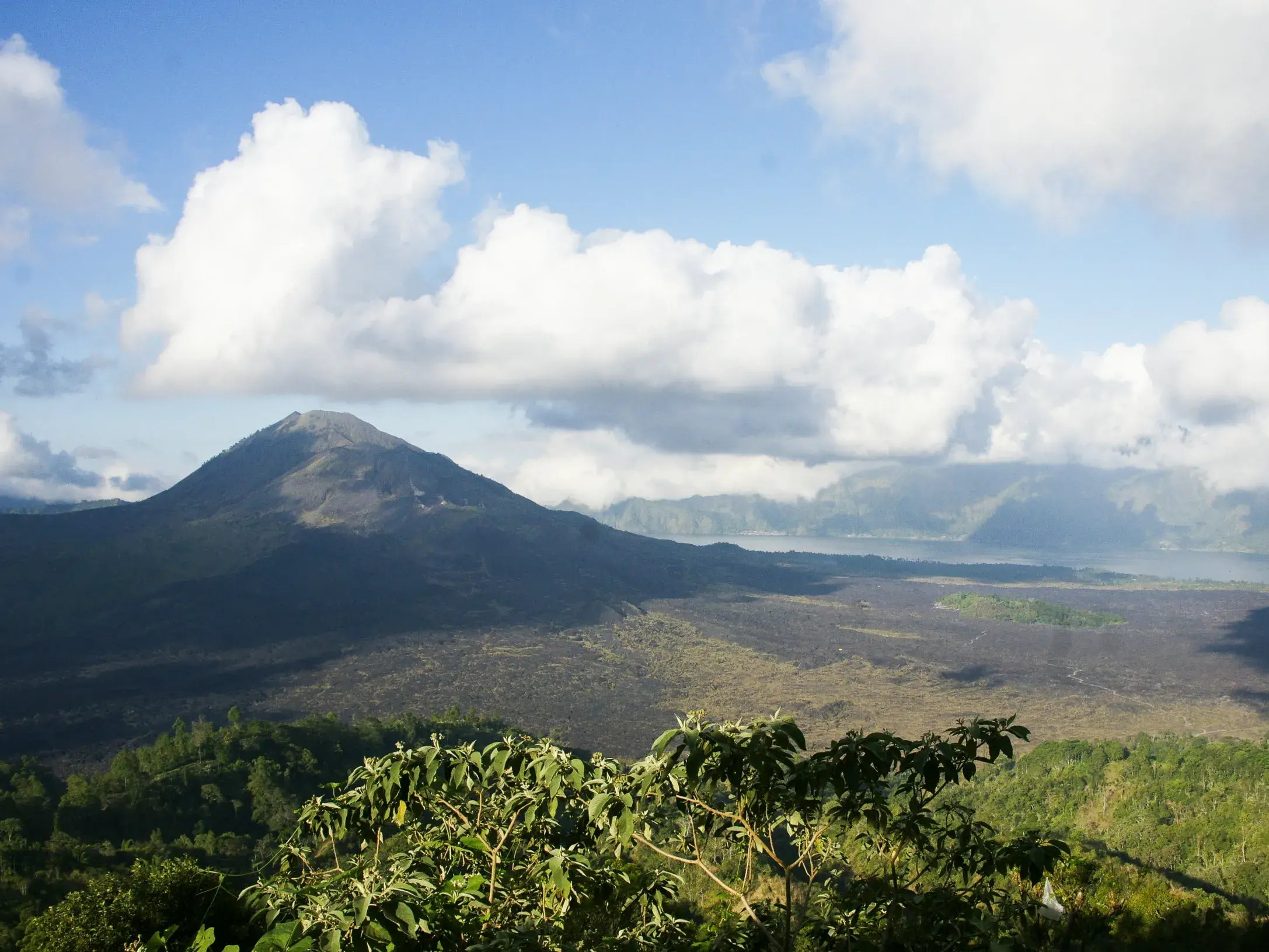 Panoramablick auf die weite Vulkanlandschaft des Gunung Batur auf Bali mit seiner dunklen Caldera und dem Batur-See.
