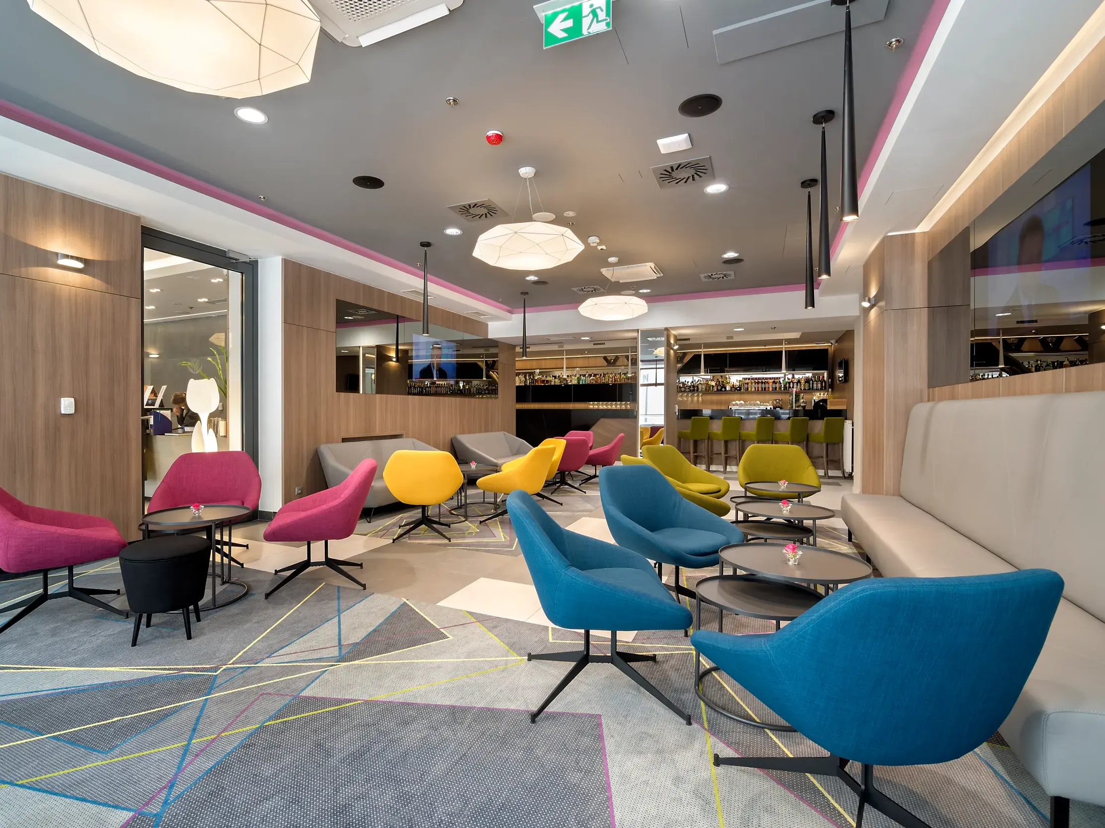 Moderne Lounge des Hotel Golden Tulip Kazimierz in Krakau mit farbenfrohen Sesseln und gemütlichen Sitzecken.