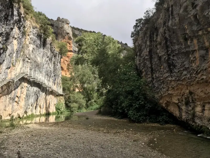 Ein hölzerner Wanderpfad schlängelt sich an einer steilen Felswand entlang durch die Schlucht des Río Verde in der Sierra de Guara.