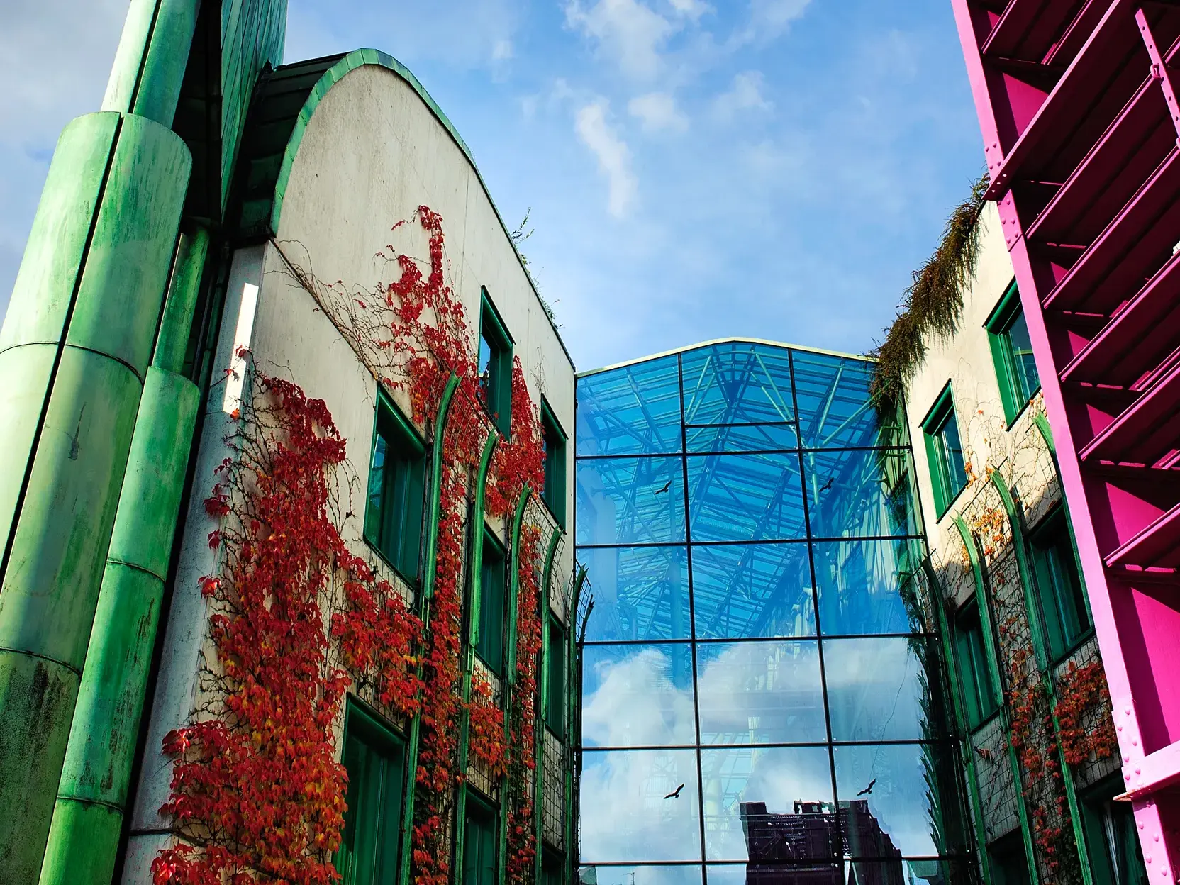 Farbenfrohe moderne Architektur in Warschau mit einer Glasfassade, die den Himmel über der polnischen Hauptstadt reflektiert.